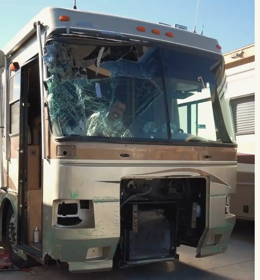Class A motorhome as it arrived, with a shattered windshield, a missing headlight and the front cap torn open