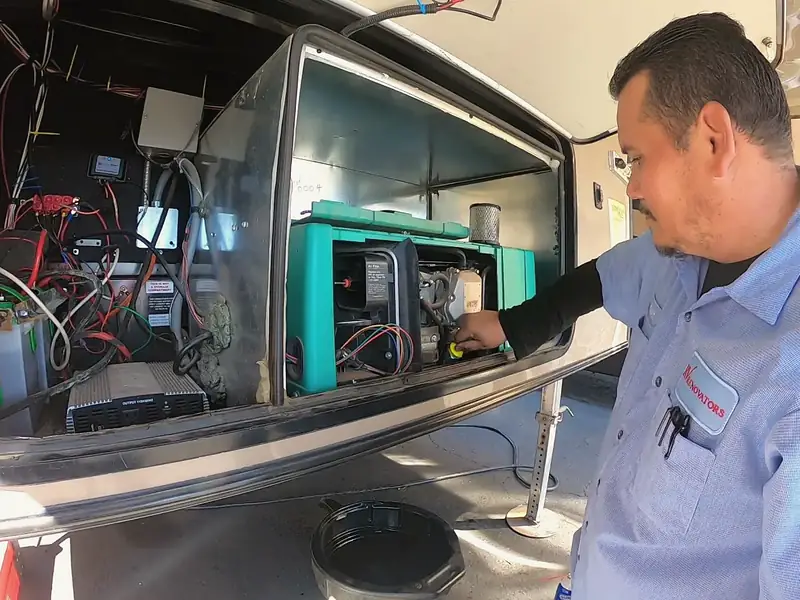 RV Renovators technician servicing a generator in a motorhome bay
