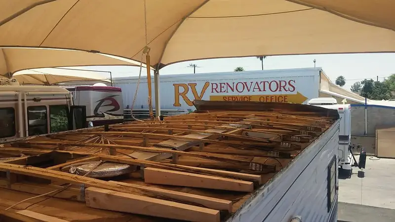 Motorhome roof opened down to new wooden framing under the shop canopy